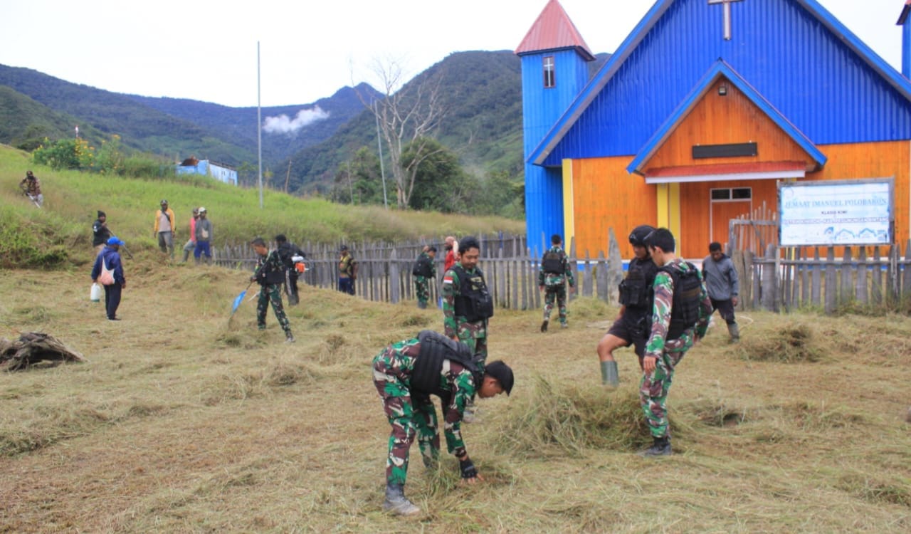 Rayakan Natal Di Kampung Sendiri, Satgas Yonif 143/TWEJ Bantu Warga Bersihkan Lingkungan Gereja